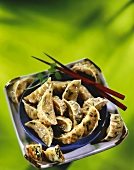 Bowl of Asian Dumplings on Plate with Chopsticks