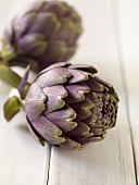 Two Purple Artichoke on Wood