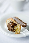 Chocolate spread on a croissant with a knife