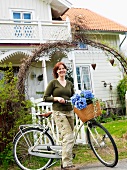 Frau mit Fahrrad vor dem Haus