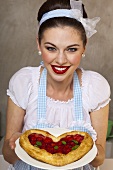A retro-style girl holding a heart-shaped puff pastry cake