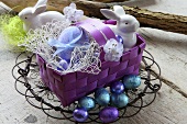 A basket of Easter eggs, porcelain rabbits and chocolate eggs