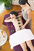 A woman having a La Stone massage in a spa