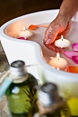 A rose petal bath with floating candles and massage oils
