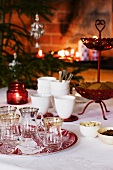 A Christmas table laid with candles, glasses and cups