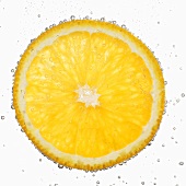 A slice of orange in water with air bubbles