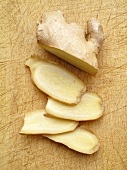 Fresh ginger, sliced, on a chopping board