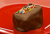 Chocolate Covered Brownie with Sprinkles on a Red Plate