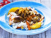 Lukewarm chicken liver salad with rice, carrots and oranges