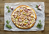 A pizza with tuna, onions and white beans