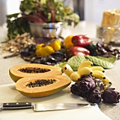 Tropical Fruit on Cutting Board; Purple Artichokes