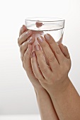 Hände halten Wasserglas