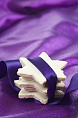 Stacked cinnamon stars wrapped with purple ribbon