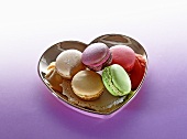 Different types of macaroons in a heart-shaped dish
