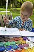 A little girl painting with water colors