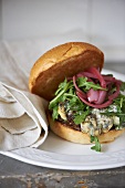 Blue Cheese Burger with Arugula and Pickled Onions on a Roll
