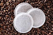 Three coffee pads on coffee beans