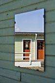 Reflection of a wooden house in a mirror