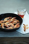 Pan Fried Shrimp in Skillet; Peels and a Glass of Beer