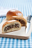 Runzas (Baked Bread Pocket Filled with Meat); Halved on Cutting Board