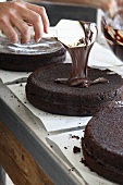A chocolate cake being glazed