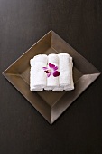 Handtücher gerollt und Orchideen