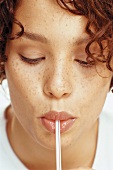 A portrait of young woman with a straw