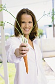Junge Frau mit einer Karotte