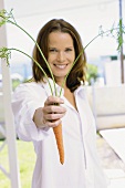 A young woman holding a carrot