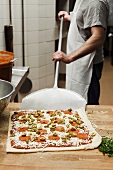 A chef making pizza in a commercial kitchen