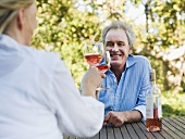 A couple toasting with wine outdoors