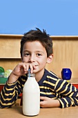 A boy drinking milk out of a bottle