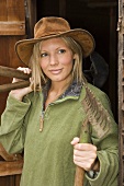 A woman holding gardening tools