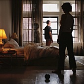 A man and a woman standing in a bedroom