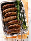 Barbecued pork sausages with rosemary in barbecue dish