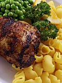 Barbecued chicken breast with noodles and peas