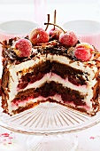 Black Forest cherry gateau on cake plate, pieces cut