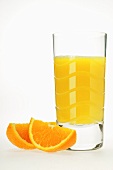 Glass of orange juice and two orange wedges