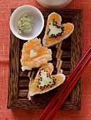 Heart-shaped sushi with salmon, cucumber and sesame; wasabi