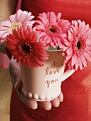 Hand holding "I love you" cup with flowers