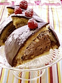 Chocolate dome cake with raspberries on cake plate