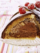 Chocolate dome cake with raspberries and icing sugar