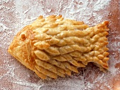 Puff pastry fish on floured chopping board