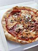 Pizza with ham and mushrooms in cardboard box