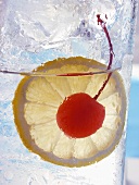 Drink with slice of lemon and cocktail cherry