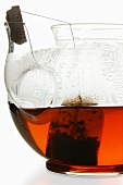 Fruit tea in glass teapot with tea bag