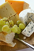 Various types of cheese with grapes and baguette