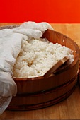 Boiled sushi rice in wooden bowl with cloth
