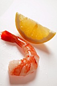 Cooked, peeled shrimp beside wedge of lemon