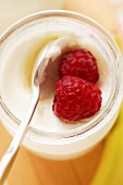 Jar of yoghurt with fresh raspberries